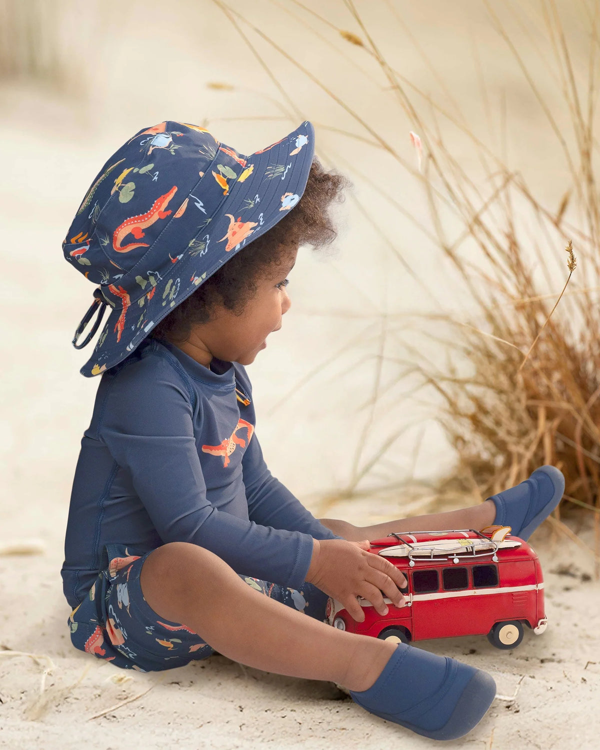 Baby wearing reef booties and matching hat, shorts and rashie